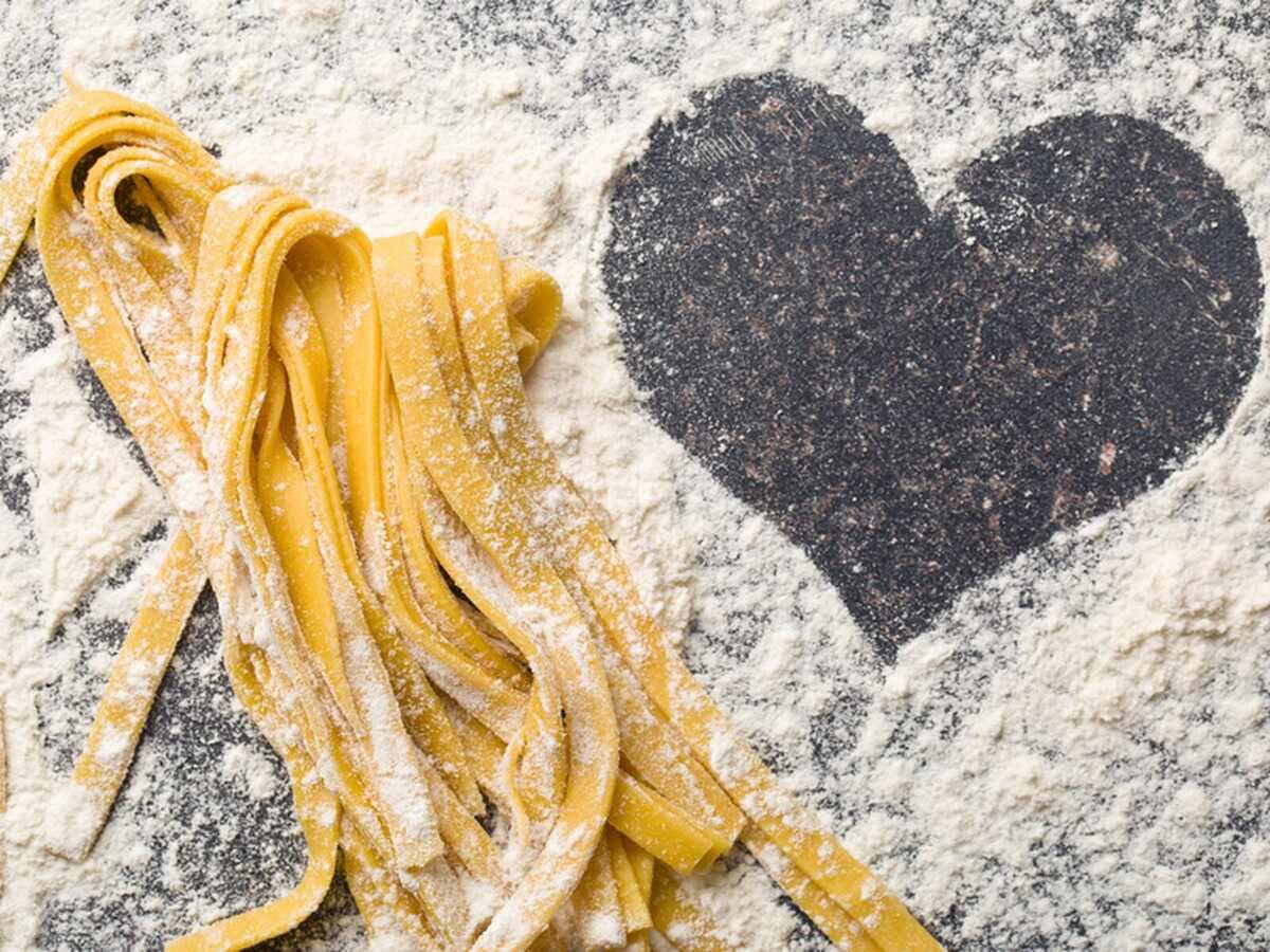 Frische Tagliatelle auf bemehlter Arbeitsfläche neben einem Herz aus Mehl, Kurs Pasta! Pasta! Pasta!